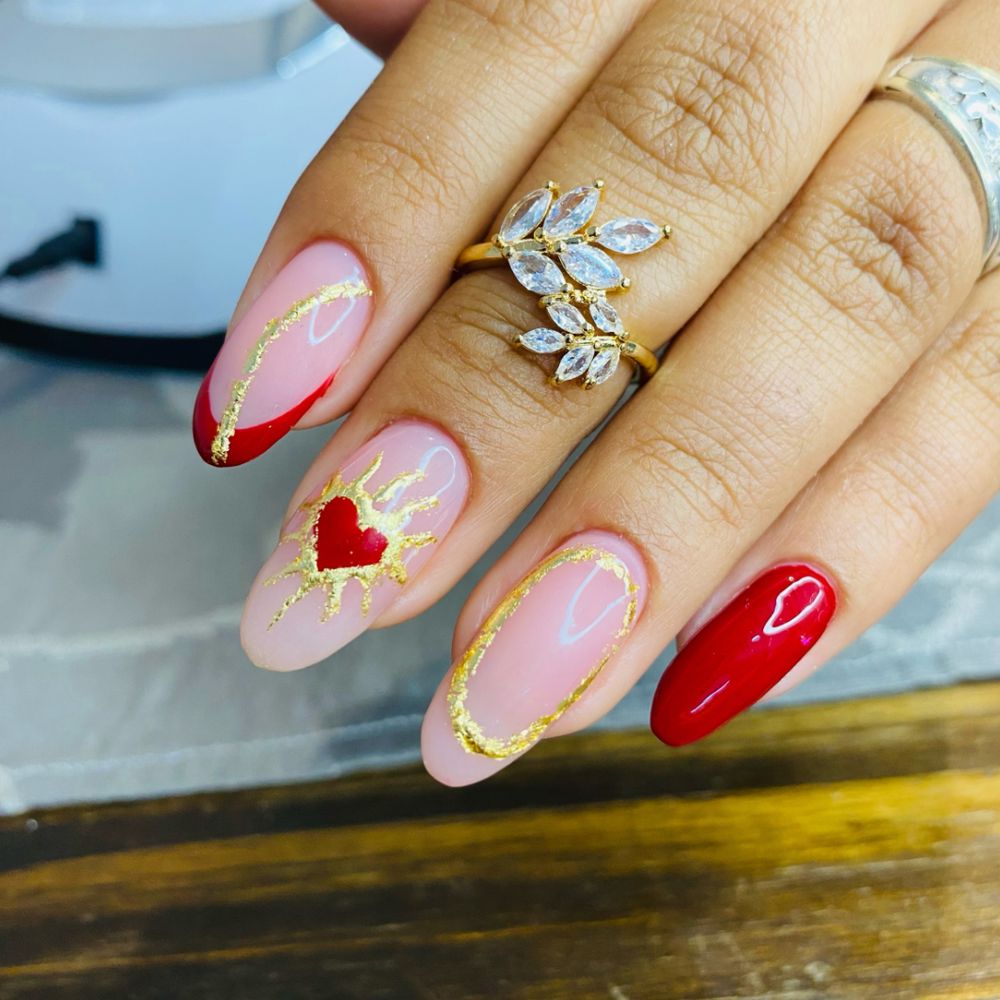 Uñas con corazón rojo y oro